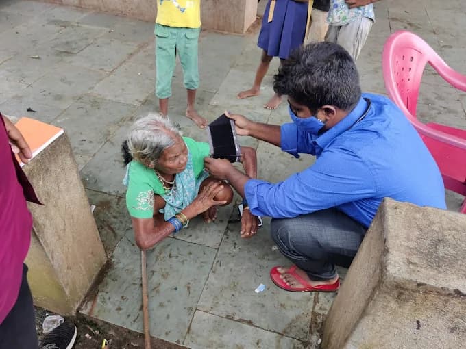 A health worker attending to an elderly patient at a camp